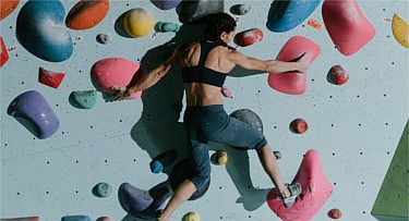 Frau klettert in Boulder Wand um in Bewegung zu bleiben
