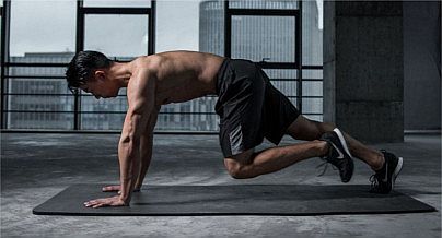 Mann macht HIIT Übung auf Matte um Fitness zu erhalten