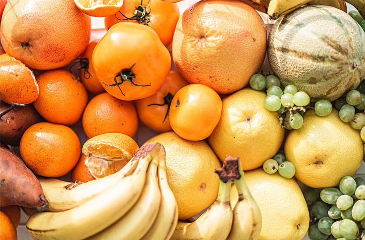 Verschieden Früchte wie Bananen, Orangen, Kürbisse und Kaki, alles Früchte die viele Vitamine enthalten